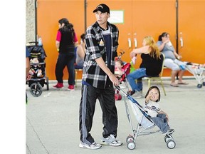 Mike Montgrand and his 18-month-old son Mikey Herman, of La Loche, were among the evacuees outside the EventPlex in Regina on Tuesday.
