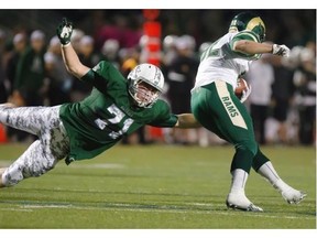 Mitch Thompson of the University of Regina Rams (white top) avoids a flying tackle by Liam Graham of the University of Saskatchewan Huskies during CIS action at Griffiths Stadium, Friday, Sept. 18, 2015.