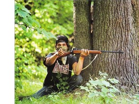 A Mohawk warrior, with a high-powered rifle, takes cover during the 1990 Oka crisis.