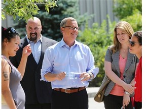 Molly Herman of La Loche, left, jokes with Saskatchewan premier Brad Wall at the evacuee centre in the Henk Ruys Soccer Centre on Thursday.