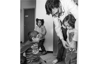 Muhammad Amir Akhter helps his children Muhammad Abdullah, Sara and Khadija with their shoes before heading off to school at River Heights on Sept. 16.