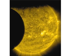 This Sept. 13, 2015 image provided by NASA shows the moon, left, and the Earth, top, transiting the sun together, seen from the Solar Dynamics Observatory. The edge of Earth appears fuzzy because the atmosphere blocks different amounts of light at different altitudes. This image was taken in extreme ultraviolet wavelengths, invisible to human eyes, but here colourized in gold. A total lunar eclipse will share the stage with a so-called supermoon Sunday evening, Sept. 27, 2015 as seen from the United States. That combination hasn’t been seen since 1982 and won’t happen again until 2033.