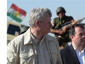 A Kurdish soldier sits in the background as Prime Minister Stephen Harper and Minister of Defence Jason Kenney visit members of the Advise and Assist mission, about 6 kilometres from active ISIL fighting positions, near Erbil, Iraq, on Saturday, May 2, 2015.