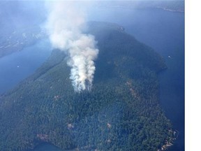 Smoke is visible from a fire near Sproat Lake on Vancouver Island in a Saturday, July 4, 2015 handout photo. Residents in parts of southern British Columbia say haze from wildfires is blotting out the sun and it looks like sunset.The B.C. Wildfire Service says gusty winds and drought conditions are hampering efforts to contain dozens of wildfires in the province. THE CANADIAN PRESS/HO-BC Wildfire Service