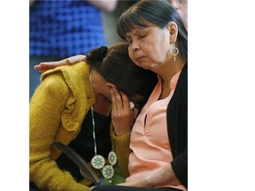 A woman is comforted at a Sixties Scoop gathering before a provincial apology by Premier Greg Selinger at the Manitoba Legislature in Winnipeg, Thursday, June 18, 2015. THE CANADIAN PRESS/John Woods