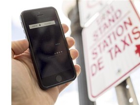 The UBER app is photographed with taxis in the background on Dalhousie St. in Ottawa Thursday September 11, 2014. (Darren Brown/Ottawa Citizen)