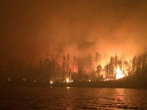 Emergency officials are warning thousands of fire evacuees from northern Saskatchewan not to go home until it's safe. Fires, such as this one near Lac La Ronge on July 13, 2015, continue to burn.