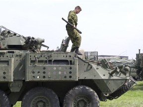 A soldier from the Prince Patricia’s Canadian Light Infantry removes a gun turret from a Light Armoured Vehicle (LAV) III. The vehicles will be used to help soldiers navigate difficult terrain. Photo taken in Prince Albert on Tuesday, July 7, 2015.