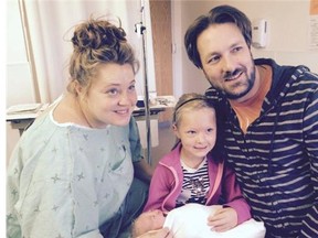 Family of Kristy Keeping, left, has started a gofundme page after she suffered an infection and stroke after giving birth. Pictured are her partner Craig Maas and daughters Peyton and Mya. Gofundme photo.