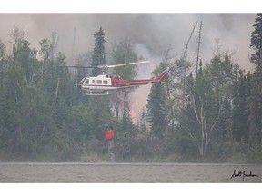 A helicopter picks up water to drop on the Eli fire at Lac La Ronge in this file photo.