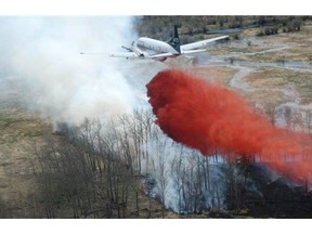 An airplane drops chemicals on a forest fire in the La Ronge area, one of 116 fires burning in Saskatchewan on Thursday.