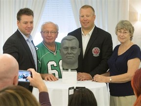 Canadian Football Hall of Fame and Museum inductees and former Riders Gene Makowsky, left, and Eddie Davis, unveil their busts during a ceremony in Saskatoon.