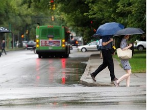 File Photo. Pedestrians cover up in early morning rain downtown.