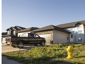 Police tape surrounds a house at 1527 Paton Crescent in Saskatoon's northeast Tuesday. Saskatoon police say major crimes officers are investigating after a woman died suddenly at the house.