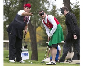 With the theme of Superhero's, Spiderman (Marc Hoffort) and Batman (Clint Gillord) help Robin (David Engdahl) with the contours of  a crucial putt on the 18th green, all in fun at the READ Saskatoon Charity Golf Fundraiser at the Saskatoon Golf and Country Club, September 14, 2015