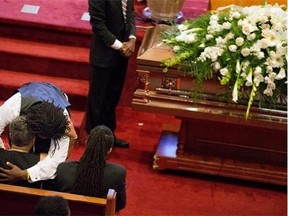 Sharon Risher, bottom, and Brandon Risher, the daughter and grandson of Ethel Lance, embrace next to Lance's casket during her funeral service, Thursday, June 25, 2015, in North Charleston, S.C. Lance was one of the nine people killed in the shooting at Emanuel AME Church last week in Charleston. (AP Photo/David Goldman)