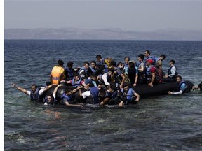 Migrants and refugees wait to cross the Greece-Macedonia border near the village of Idomeni, in northern Greece on September 13, 2015.