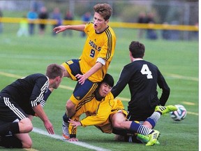 Noah Guenther, standing, and teammate Steven Chang of Evan Hardy collide while trying to score against St. Joe's Guardians players Colton Loehndorf, left, and Kyle Sader during high school soccer action at the SaskTel Sports Centre on Monday.