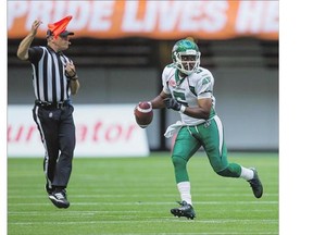 An official throws a penalty flag as Saskatchewan Roughriders' quarterback Kevin Glenn looks for an open receiver during CFL action in early July. The propensity of penalty flags has been a major concern in the league this season.