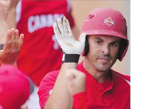 Outfielder Jeff Ellsworth celebrates in the dugout with his teammates. Ellsworth went two for two with two runs and two RBIs including a home run Wednesday against Great Britain. Team Canada clinched first place in their WBSC World Men's Softball Championship round robin pool with the 11-1 win.