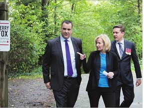 Outgoing Conservative MP James Moore, left, Stephen Harper's wife Laureen Harper, and local Conservative candidate Tim Laidler in Port Moody, B.C., on Sunday. Moore made funding for cancer research contingent on Harper's reelection.