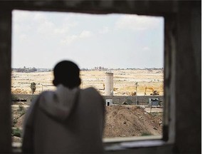 A Palestinian man looks at bulldozers and diggers working at the Egyptian side of the border of the Gaza Strip.