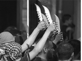 Palestinian protesters brandish knives during a demonstration in the Jabalia refugee camp in northern Gaza on Friday. A wave of attacks that have killed eight Israelis in the past month has shaken the country.