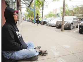 Panhandler Herman Deschambeault-Turcot sits on Second Avenue Friday waiting for passersby to leave money in his hat.