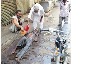 People in Karachi help a heatstroke victim at a market as temperatures reached 45 C in the city.
