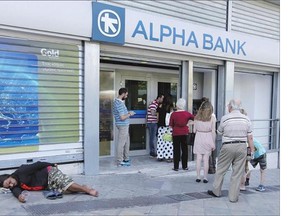 People queue to use a bank machine in Athens, Monday as a person begs for alms. Though its debt remains the chief impediment to Greece's recovery, mere debt forgiveness, without more substantive reforms, is unlikely to be the remedy.
