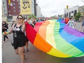 People walk down 20th Street East during the Pride Parade in Saskatoon on Saturday.