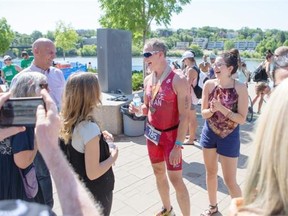 Tim Pierce enjoys a laugh and some wear after crossing the finish line during the Subaru triathlon at River Landing on Sunday June 28th, 2015.