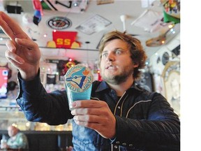 Piper Burns, at Leopold's Tavern bartender, with his 'Leo's Holy Water' in Regina on Tuesday, says the secret potion takes nine hours to make. There's now a crowdfunding campaign to raise $2,500 to help cover his costs of going to Game 5 in Toronto.