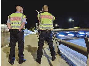 Police officers observe the traffic at the border between Germany and Austria, in the southern German city of Freilassing after Berlin's shock decision to reintroduce controls to halt a surge in refugee numbers. German federal police said Sunday hundreds of officers were being deployed to carry out the newly reintroduced border controls.
