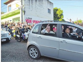 Pope Francis waves from a car as he arrives to visit the people of the Banado Norte shantytown in Asuncion, Paraguay on Sunday. Pope Francis visited the poorest neighbourhood of Paraguay before ending his Latin American tour.