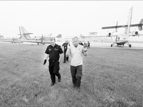 Premier Brad Wall, right, and Emergency Management and Fire Safety Commissioner and Executive Director Duane McKay tour water tanker planes at the airport in Prince Albert on June 30.