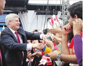 Prime Minister Stephen Harper shakes hands on Canada Day. A long campaign could favour the Conservative Party and its large war chest, columnist Stephen Maher writes.