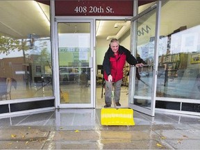 Principal trumpeter with the Saskatoon Symphony, Terry Heckman, shovels rain water seeping in under the symphony building's door on Tuesday when an estimated 10-15 mm of rain fell on the city.