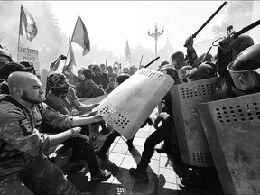 Protesters try to pull shields away from officers as activists clashed outside the parliament in Kyiv on Monday.