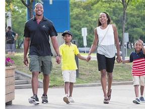 Redblacks quarterback Henry Burris takes a stroll in Ottawa with his family including, son Armand, second from left, wife Nicole and son Barron. Burris has spent his pro career in Canada, and now he and his wife have applied to become Canadian citizens.