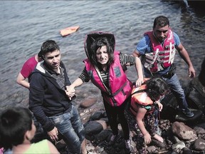 Refugees land on the shores of the Greek island of Lesbos, across the Aegean Sea from Turkey, on Thursday.