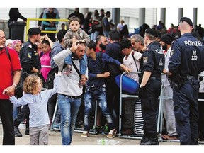 Refugees walk through a police barrier on the border to Hungary in Nickelsdorf, 70 kilometres southeast of Vienna on Monday. Austria says it will follow Germany's lead.