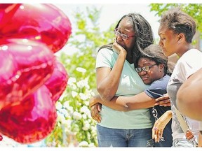 Relatives of DePayne Middleton-Doctor embrace and weep while visiting a makeshift memorial outside the Emanuel African Methodist Episcopal Church where Doctor and eight others were shot to death in Charleston, S.C.