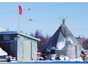 The remains of a Canadian flag can be seen flying over a building in Attawapiskat. A new report shows the prosperity gap between aboriginal and non-aboriginal people is widening.