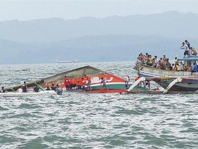 Rescuers help passengers from a capsized ferry Thursday in Ormoc, Philippines. Dozens were killed in the incident.