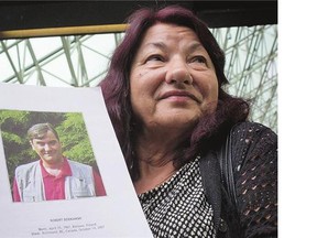 Robert Dziekanski's mother, Zofia Cisowski, shows a photo of her late son in the Braidwood Commission report, outside B.C. Supreme Court Friday after former Mountie Benjamin Robinson was sentenced for lying to an inquiry in the death of her son.