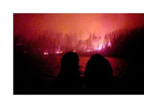 Lac La Ronge Indian Band Chief Tammy Cook-Searson and Councillor Linda Charles survey the Ant Island fire by boat early Monday morning.