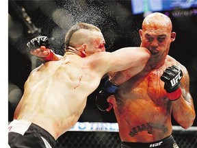 Rory MacDonald, left, and Robbie Lawler exchange blows in their welterweight title mixed martial arts bout at UFC 189 on Saturday in Las Vegas.