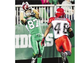 Roughriders' Alex Carroll catches a touchdown pass thrown by Kevin Glenn while Calgary Stampeders' Royce Adams guards him during third-quarter pre-season action at Mosaic Stadium on Friday. The Riders lost 37-29.
