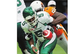 Saskatchewan Roughriders' quarterback Kevin Glenn fumbles the ball while being tackled by B.C. Lions' Jabar Westerman during the first half of a CFL football game in Vancouver on Saturday. B.C. recovered the ball on the play.